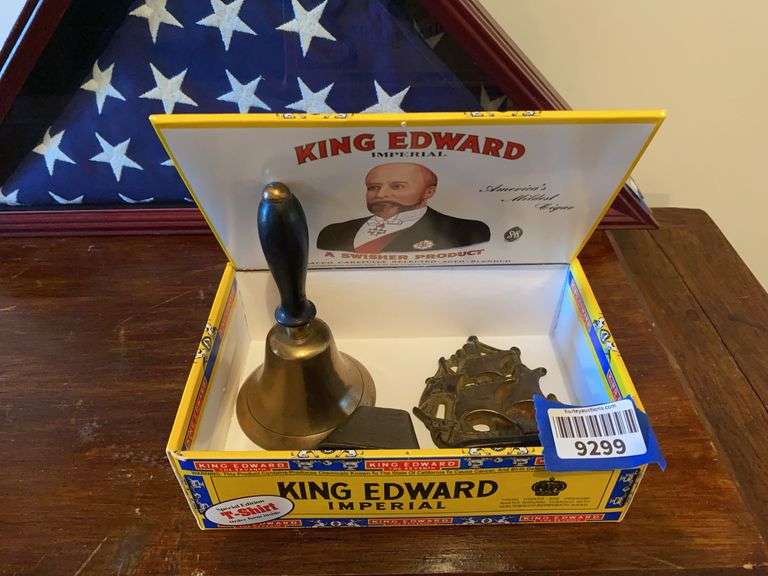 Brass hand bell, cow bell, and cast iron ship bookend, in cigar box