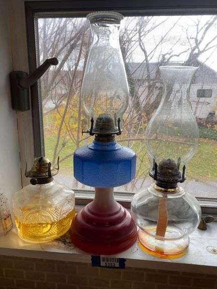 Three glass oil lamps, one is painted red/white/blue