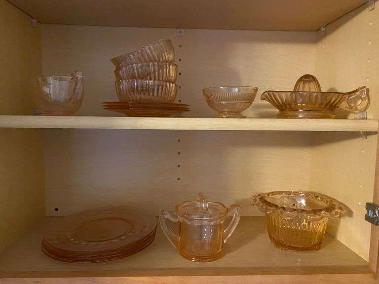 Contents of two shelves: pink depression glass: juice reamer, plates, bowls, sugar bowls