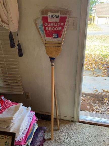 Two unused brooms in packages