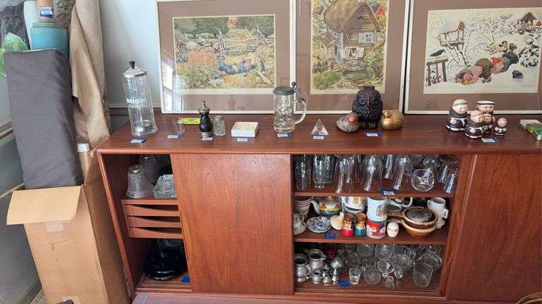 Interior contents of cupboard: vintage ashtrays, glassware, china, mugs, glass lamp shades - no top contents