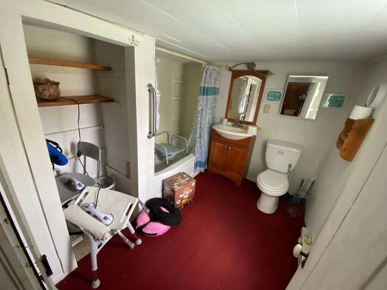 Contents of bathroom: shower seats, heated mattress pad, walker, commode chair, wall clock, misc