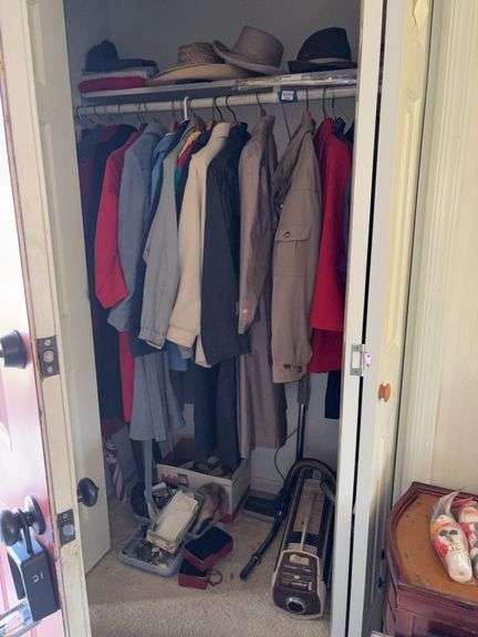 Contents of closet: clothing and accessories, fur hat, vacuums