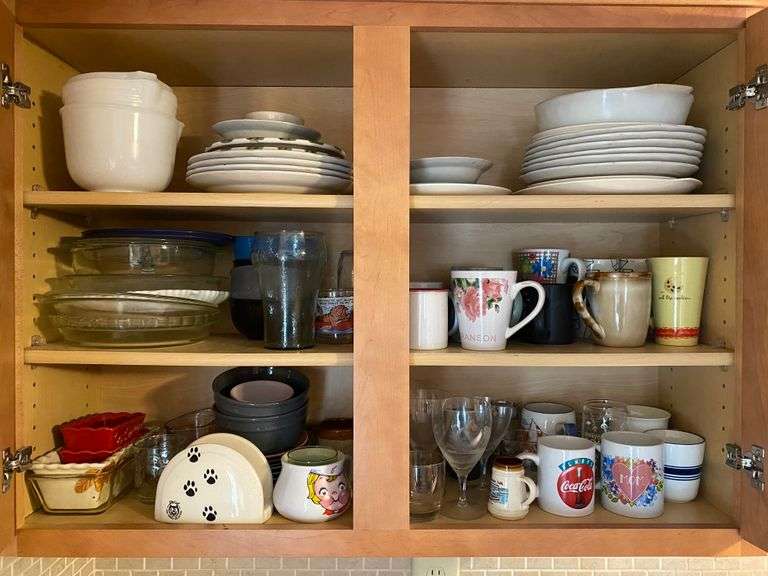Contents of cupboard: glass bakeware, dishes, mugs, mixing bowls
