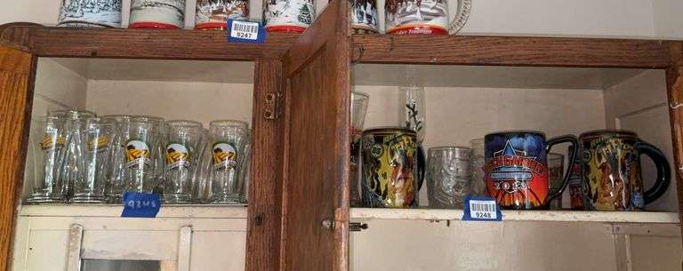 Contents of shelf: decorated beer glasses, Coca-Cola glass, Busch Gardens mugs