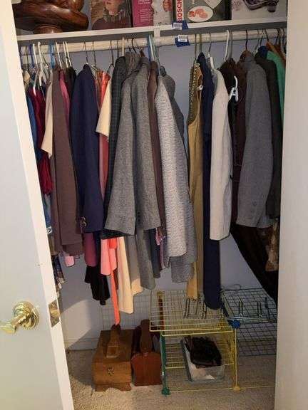 Clothing hanging in closet and contents of floor: shoeshine kits, organizers, gloves