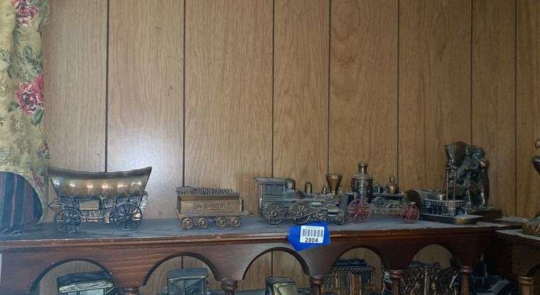 Contents of one what-not shelf - cast metal train, chuck wagon, stem engine, steam boat, Spirit of ‘76