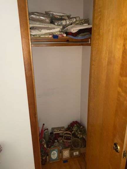 Contents of living room closet - candles, baskets, framed prints