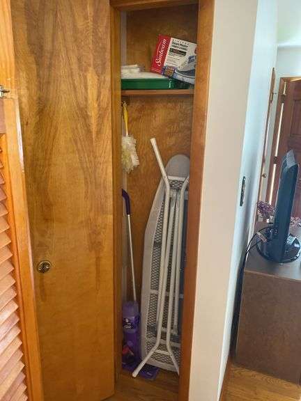 Contents of hall closet - ironing board, iron, cleaning tools