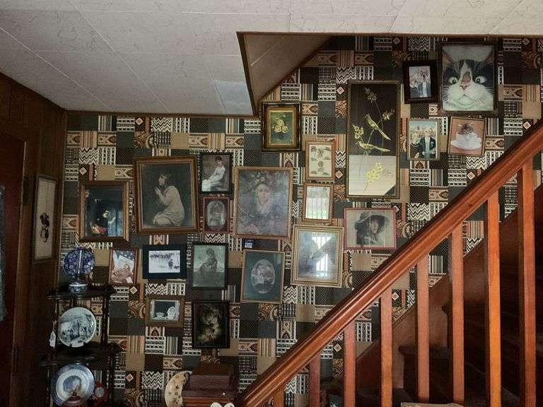 Framed picture collection on wall of stairway: portraits, animals, misc