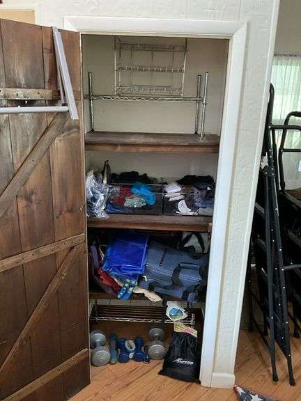 Contents of closet: hand weights, wire shelving, luggage, bags, misc