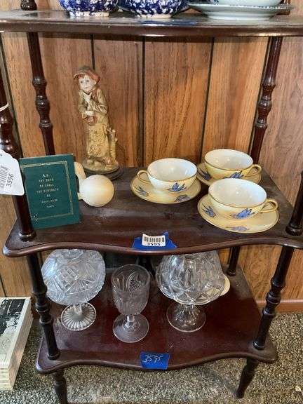 Contents of two shelves: handpainted bluebird cups/saucers, New England Pineapple goblet, covered compote, glass candle lamp