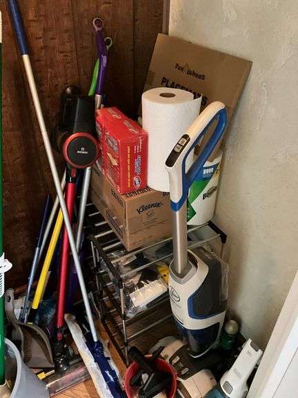 Contents of closet: MooSoo vacuum, Hoover upright vacuum, hand vac, cleaning supplies, Swiffer and refills, drawer unit, metal shelf unit, hangers, misc