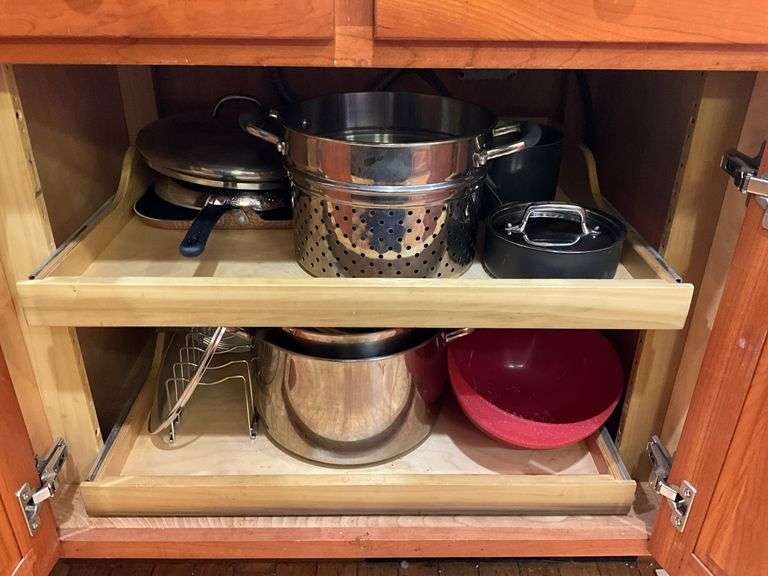 Contents of cupboard: cookware, steamer basket, lid rack