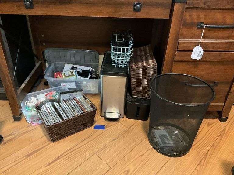 Contents of desk top and underneath: metal lamp, cable modem, twin, puzzles, office supplies, tape, waste cans, CDs, misc