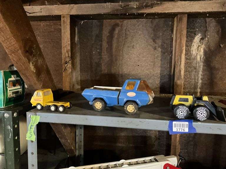 Contents of shelf: Tonka toy trucks and earthmover, Tonka dunebuggy, Nylint trailer