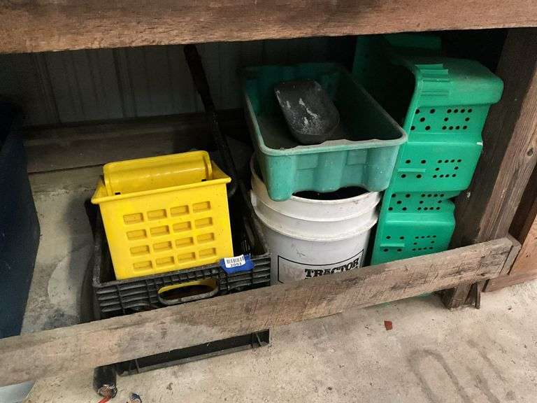 Items under workbench: plastic containers, mop wringer, grout and sand