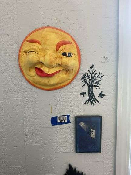 Wall hangings: winking moon face, tree cutout, framed print, sawn leaf bracket shelf