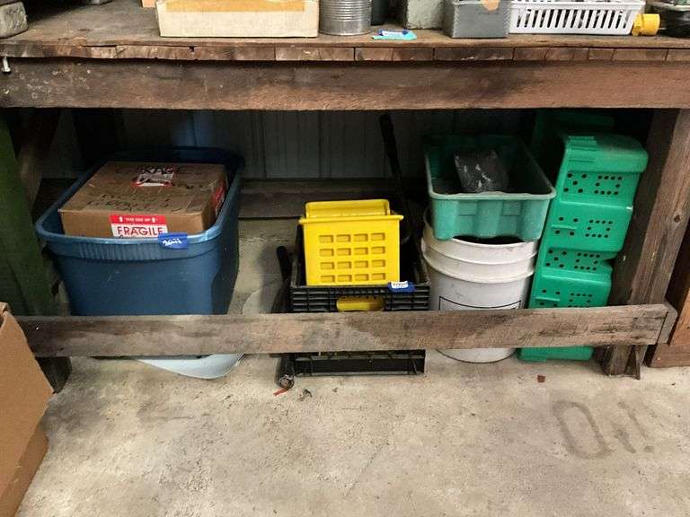 Items under workbench: plastic containers, mop wringer, grout and sand