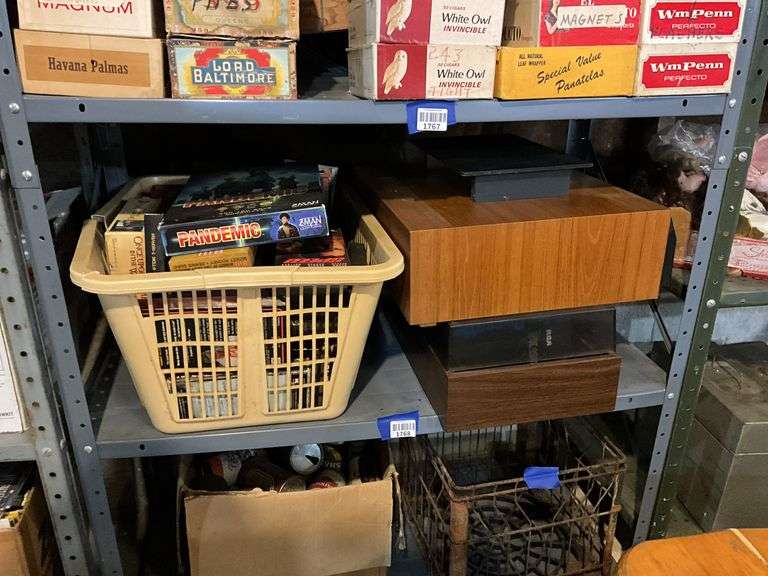 Contents of shelf: video game, VHS tapes, tape storage cases