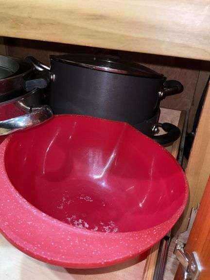 Contents of cupboard: cookware, steamer basket, lid rack