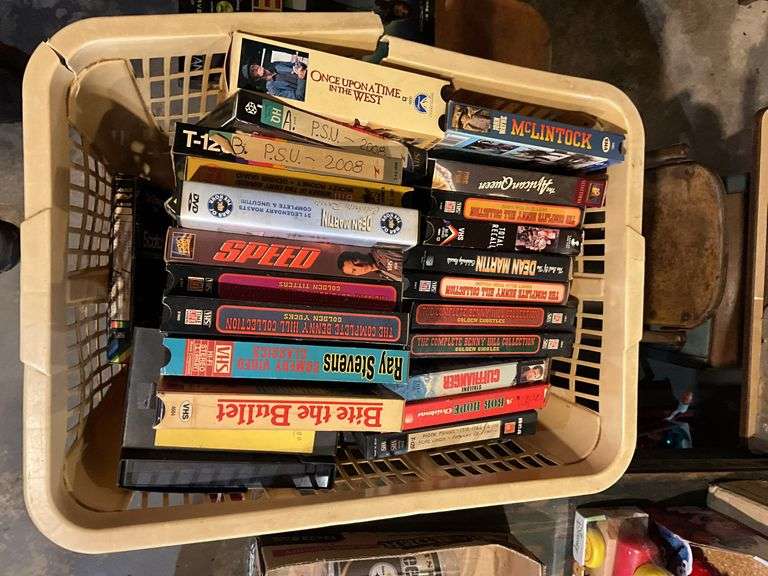 Contents of shelf: video game, VHS tapes, tape storage cases