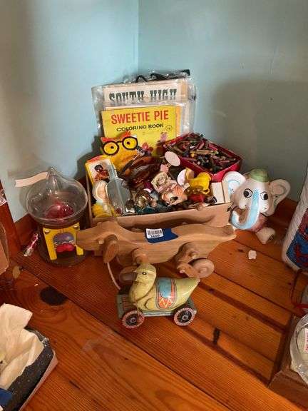 Corner lot: wooden pull toys, ceramic elephant bank, chalkware owl plaque, toys, vintage coloring book, misc