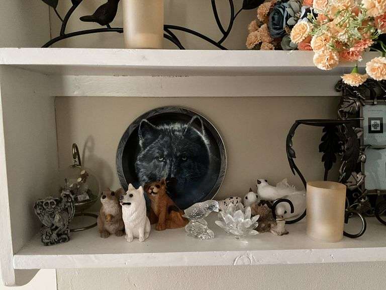 Contents of two shelves: anniversary style clock, votive holders, figurines, decor items