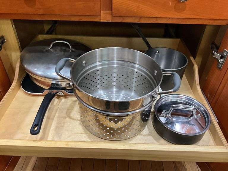 Contents of cupboard: cookware, steamer basket, lid rack