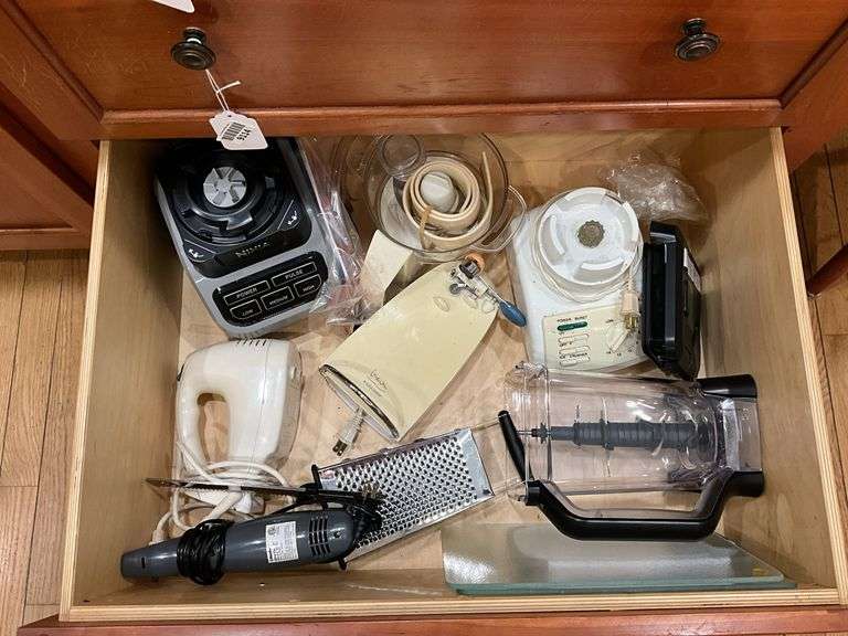 Contents of drawer: blenders, electric knife, hand mixer, grater