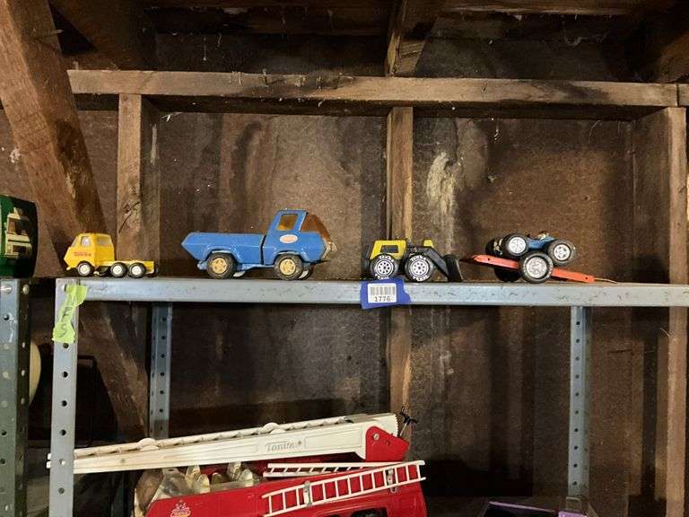 Contents of shelf: Tonka toy trucks and earthmover, Tonka dunebuggy, Nylint trailer