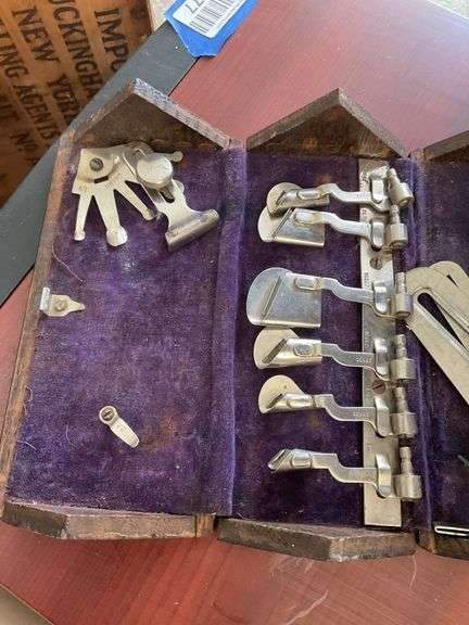 Antique sewing machine attachments in hinged box