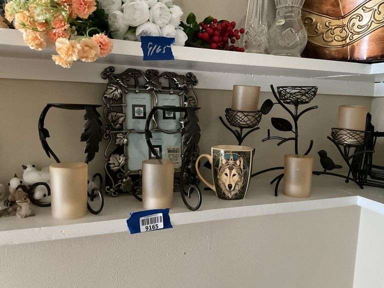 Contents of two shelves: anniversary style clock, votive holders, figurines, decor items