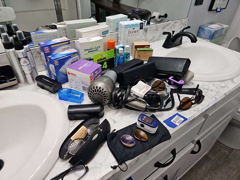 Contents of vanity top and drawer: blow dryer, glasses, health/hygiene products, face masks, two profile wall plaques