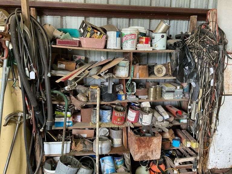 Contents of shelf unit: hardware, hose, electrical cords, sprayer, galvanized watering can, misc