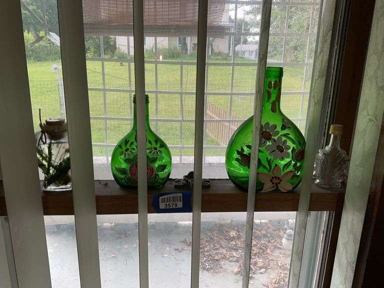Contents of window ledge: handpainted green glass bottles, two clear bottles