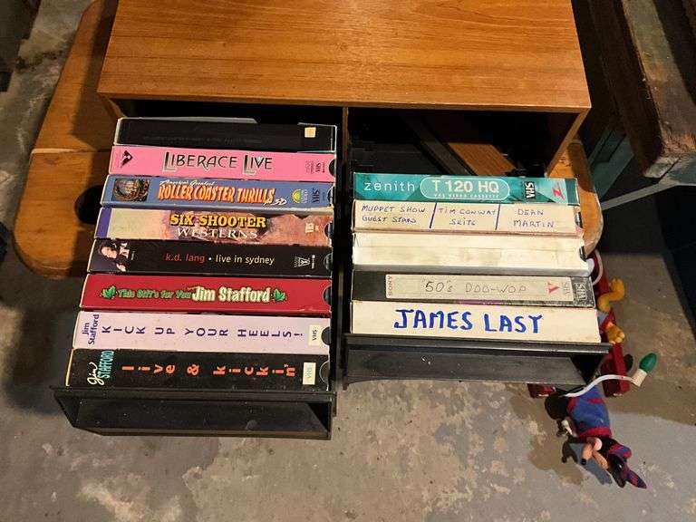 Contents of shelf: video game, VHS tapes, tape storage cases
