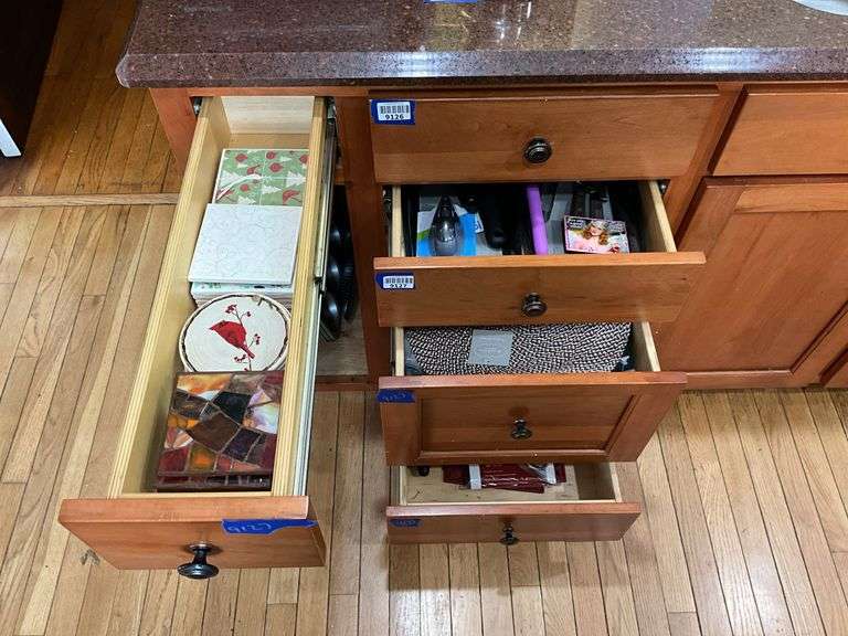 Contents of four drawers and one cupboard: coasters, baking pans, gadgets, hot pads, rolling pin, misc