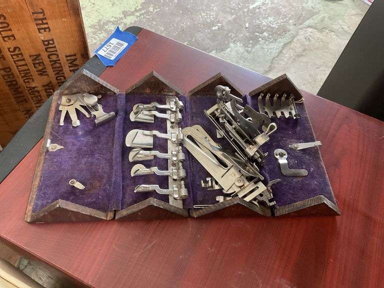 Antique sewing machine attachments in hinged box