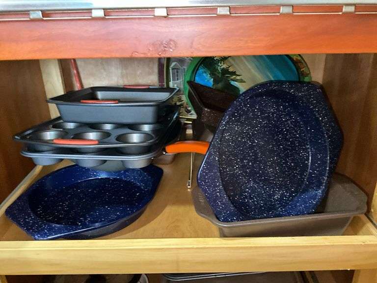 Contents of cupboard: Corningware casseroles, various baking pans, trays