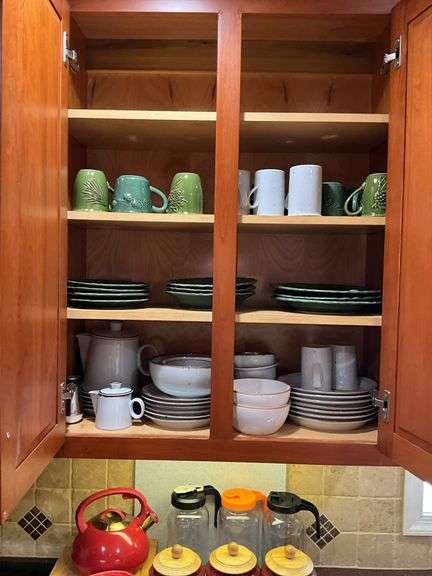 Contents of cupboard: Dansk stoneware dinnerware, green glazed pinecone motif dinnerware