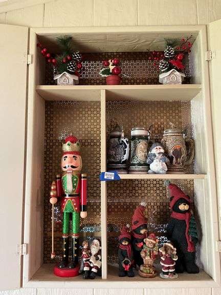 Contents of cupboard: nutcracker, Christmas figurines and decor, beer steins