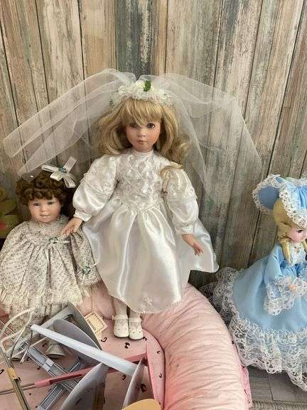 Five porcelain collector dolls, doll stands, cushion