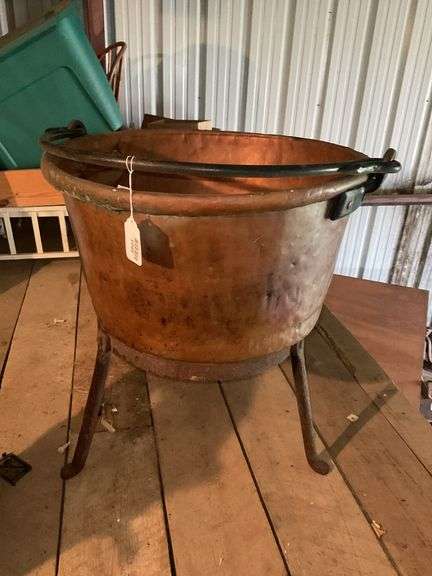 Copper butchering kettle w/ bail handle, on 3-legged stand, *** PLEASE NOTE: This item has no stair access and must be picked up on July 15th between 11:00-1:30PM. Item will be removed from loft for pickup.
