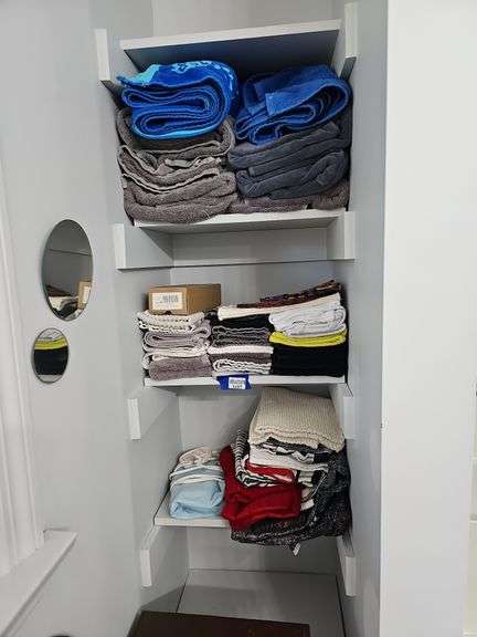 Contents of three shelves: towels, linens, heating pad