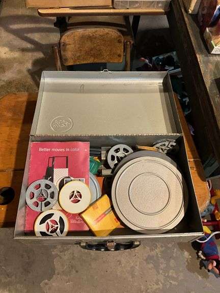 Contents of shelf: vintage cosmetic case, movie reels, metal toolbox, roll of plastic