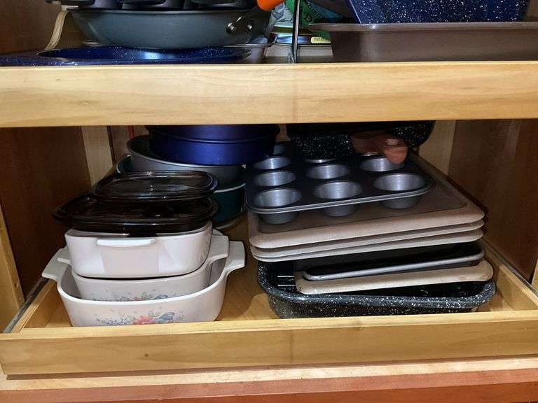 Contents of cupboard: Corningware casseroles, various baking pans, trays