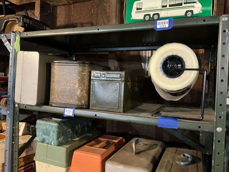 Contents of shelf: vintage cosmetic case, movie reels, metal toolbox, roll of plastic
