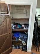Contents of closet: hand weights, wire shelving, luggage, bags, misc