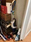 Contents of closet: MooSoo vacuum, Hoover upright vacuum, hand vac, cleaning supplies, Swiffer and refills, drawer unit, metal shelf unit, hangers, misc
